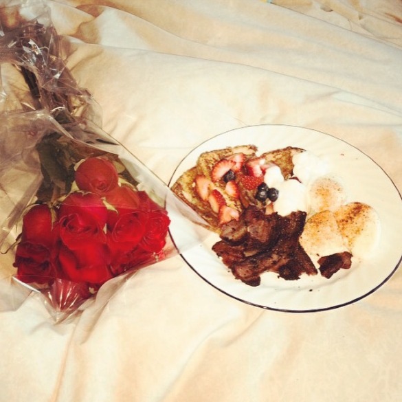A dozen roses & breakfast in bed with French toast, strawberries, blueberries, poached eggs, & bacon